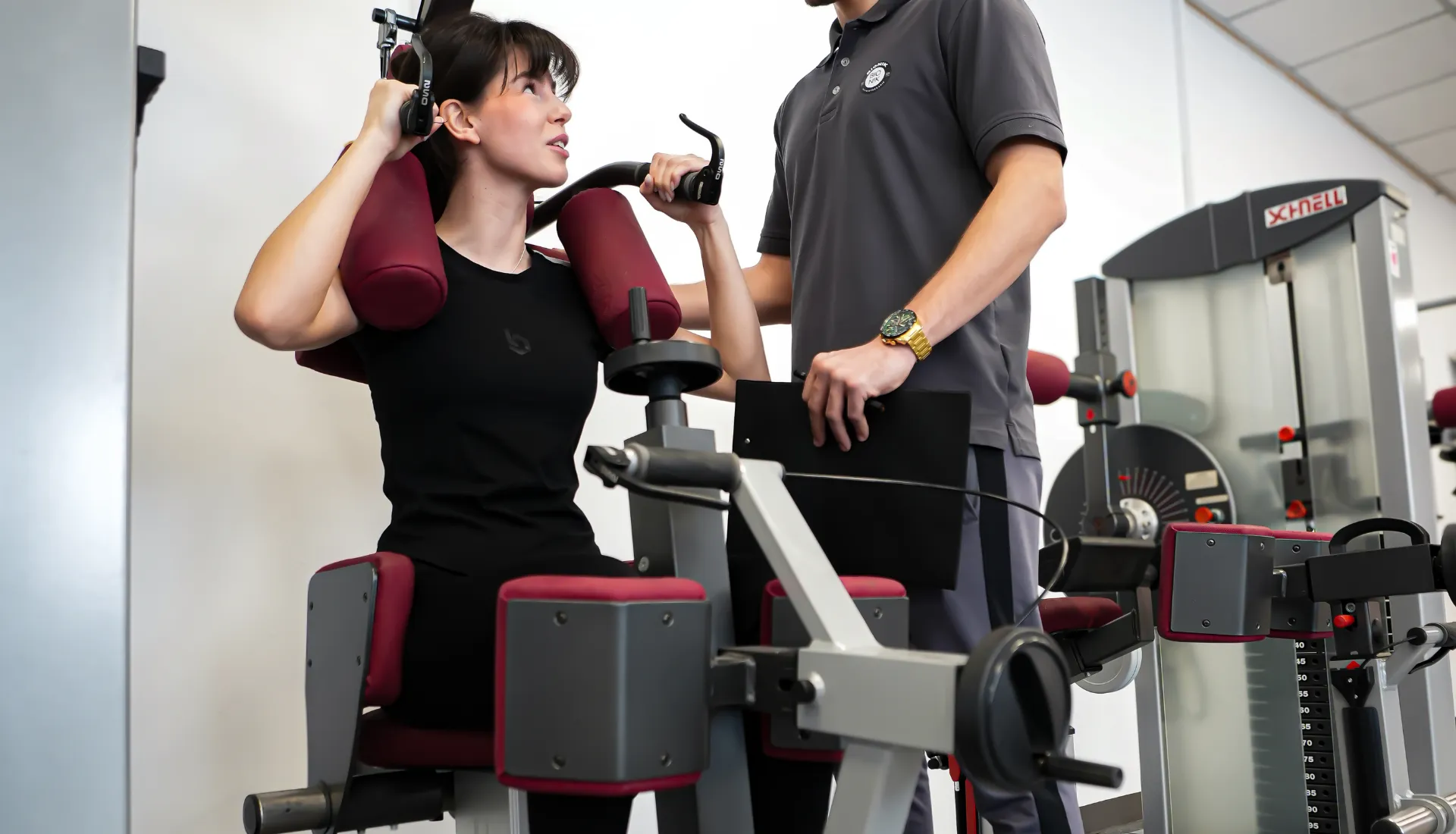 Patientin trainiert an einem Schnell-Trainingsgerät, begleitet von einem BIONIK-Therapeuten