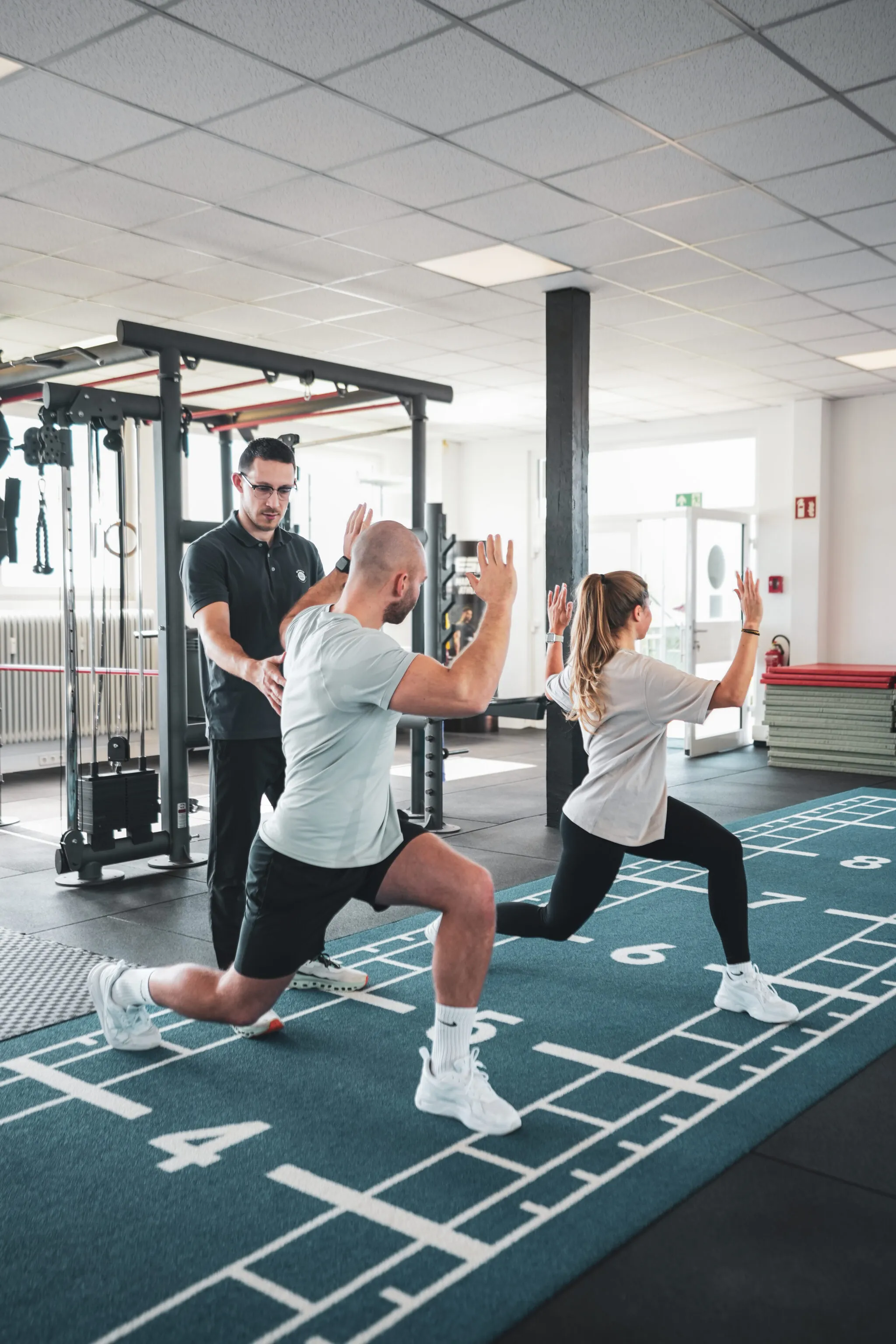BIONIK-Therapeut begleitet zwei Personen beim funktionellen Training auf der Sprinttrack-Fläche